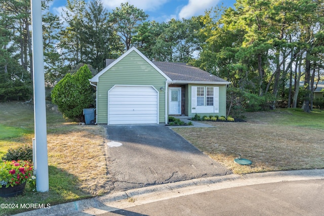 view of front of house featuring a garage, driveway, and a front yard