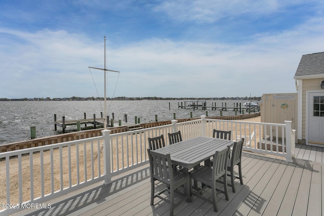 wooden deck featuring boat lift, outdoor dining space, a water view, and a dock