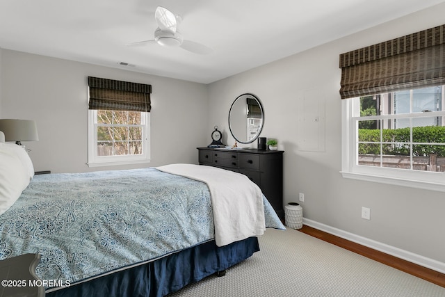 bedroom featuring ceiling fan, baseboards, visible vents, and wood finished floors