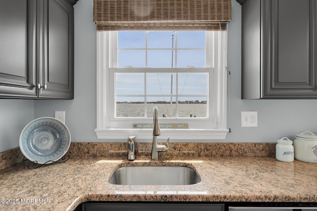 kitchen featuring gray cabinetry, a healthy amount of sunlight, and a sink