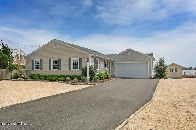 single story home featuring fence, an attached garage, and driveway