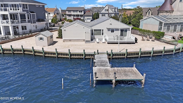 dock area with fence, a residential view, and a deck with water view