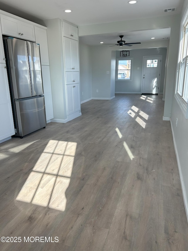 unfurnished living room with recessed lighting, ceiling fan, visible vents, baseboards, and wood finished floors