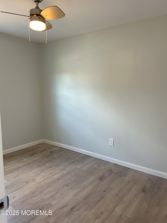 unfurnished room featuring wood finished floors, ceiling fan, and baseboards