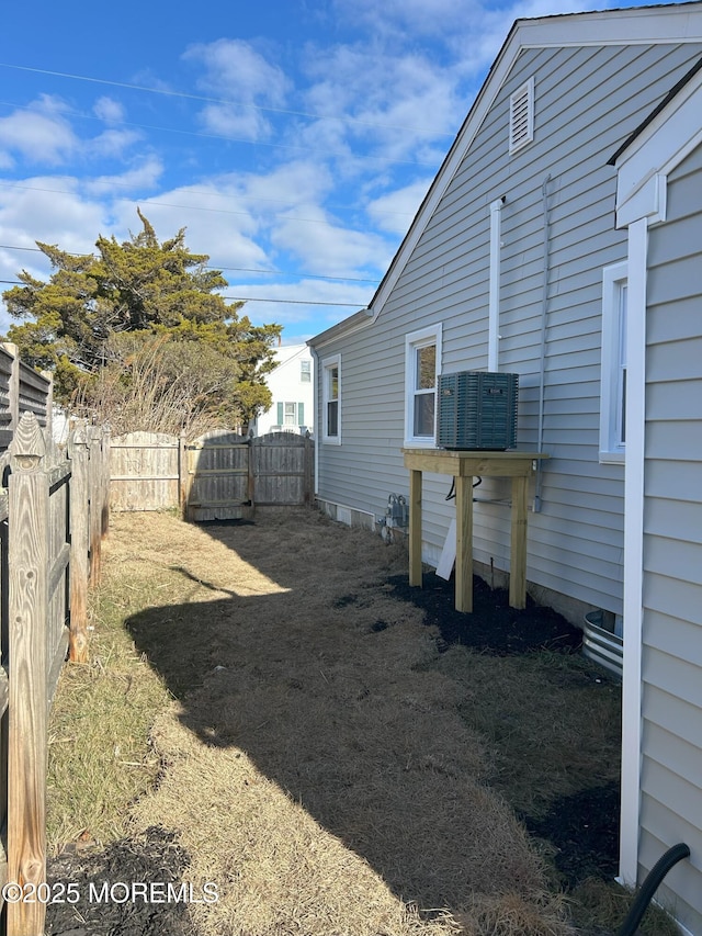 view of yard featuring fence and central air condition unit