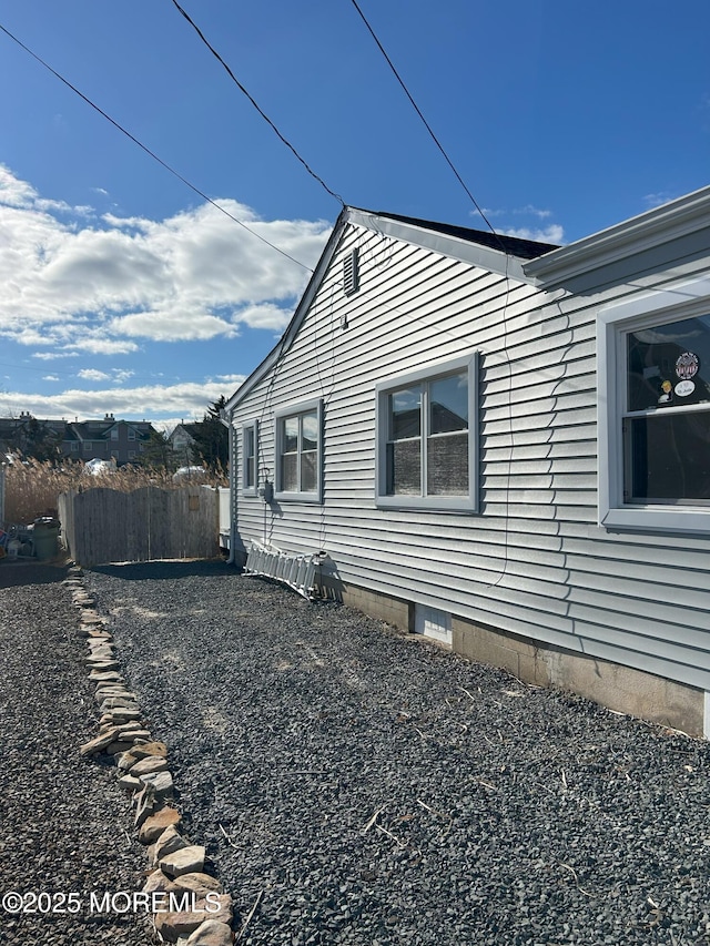 view of home's exterior featuring crawl space and fence