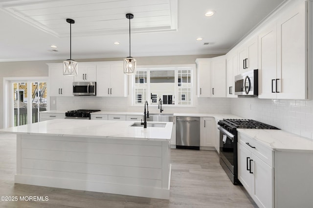 kitchen featuring crown molding, stainless steel appliances, white cabinetry, and tasteful backsplash