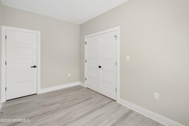 unfurnished bedroom featuring light wood-style floors and baseboards