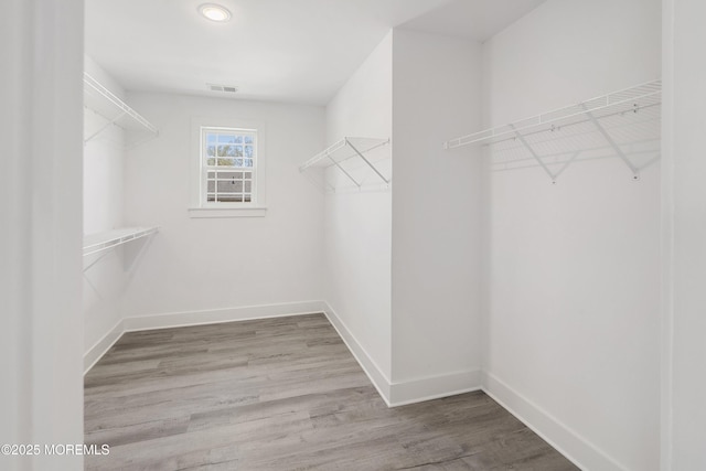 walk in closet featuring visible vents and wood finished floors