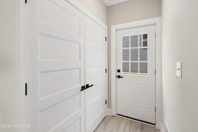 doorway to outside with baseboards and light wood-style flooring