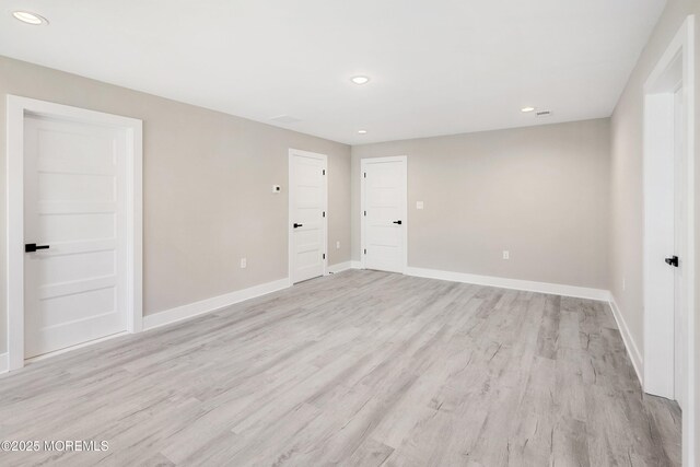 empty room with baseboards, recessed lighting, and light wood-style flooring