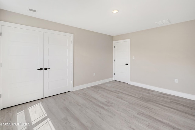 unfurnished bedroom featuring visible vents, baseboards, a closet, recessed lighting, and light wood-style flooring