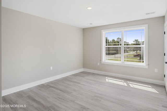 empty room featuring visible vents, recessed lighting, baseboards, and wood finished floors