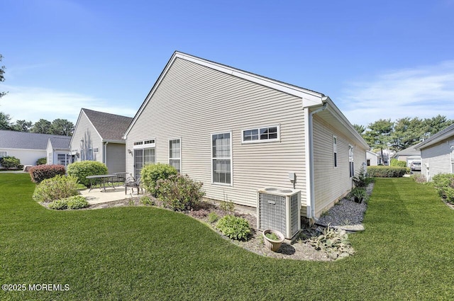 view of side of home with a patio, central AC unit, and a lawn