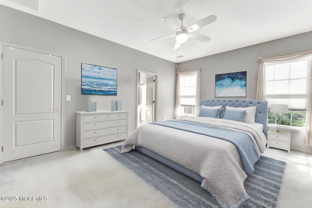 bedroom with a ceiling fan, baseboards, light colored carpet, and visible vents