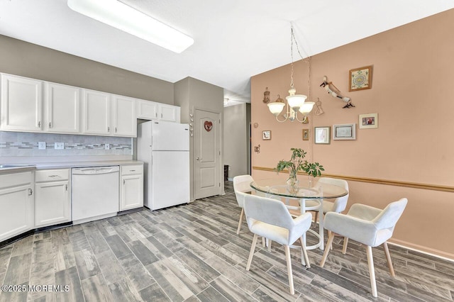 dining space with light wood finished floors and a notable chandelier
