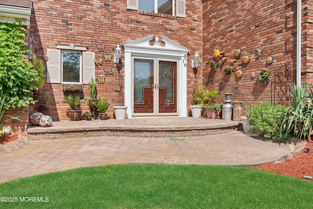 property entrance featuring brick siding and french doors