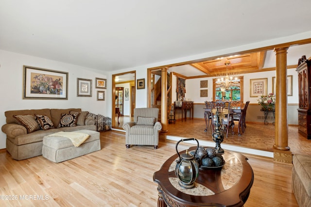 living area with light wood-style floors, baseboards, ornate columns, coffered ceiling, and a notable chandelier