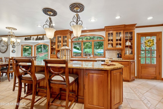 kitchen with recessed lighting, brown cabinets, light stone counters, a sink, and light tile patterned floors