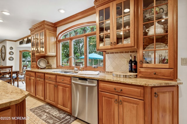 kitchen with light stone counters, a sink, backsplash, light tile patterned floors, and stainless steel dishwasher