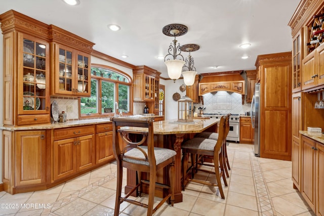 kitchen featuring decorative backsplash, light stone countertops, light tile patterned floors, stainless steel appliances, and recessed lighting