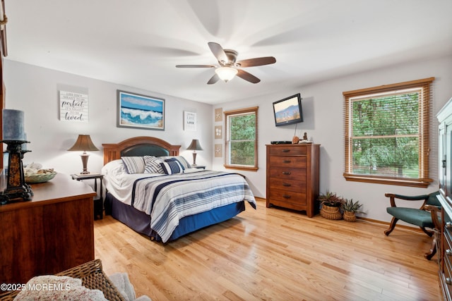bedroom featuring ceiling fan, baseboards, and light wood finished floors