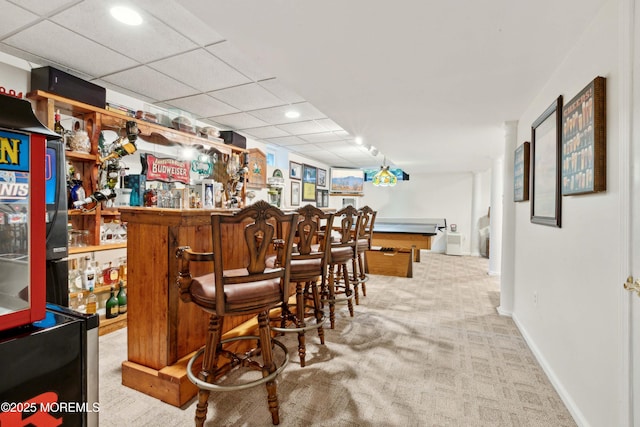 bar with a dry bar, carpet floors, baseboards, a drop ceiling, and recessed lighting