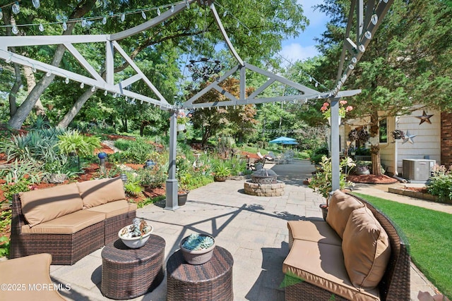 view of patio with central AC unit and an outdoor living space with a fire pit