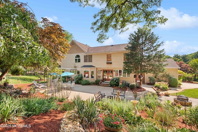 rear view of house with french doors, a fire pit, and a patio area