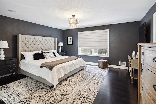 bedroom with baseboards, dark wood-type flooring, and visible vents