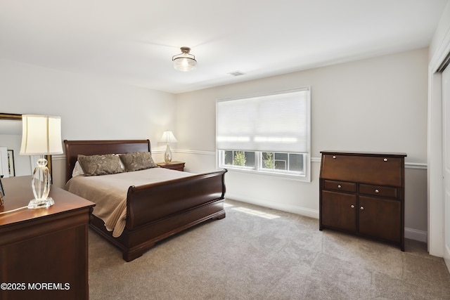 bedroom with baseboards, light carpet, and visible vents