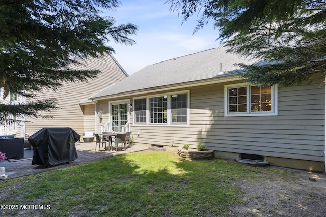 rear view of house featuring a patio and a lawn