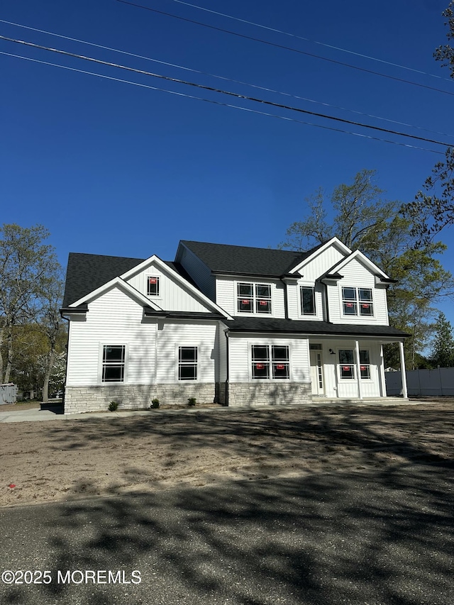 view of front of property with a porch, board and batten siding, and stone siding