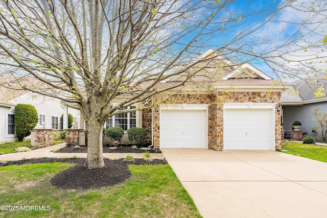 view of front facade with an attached garage, driveway, and stone siding