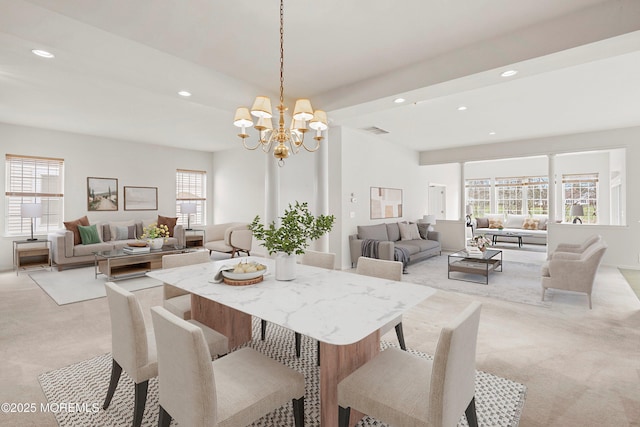 dining room with light colored carpet, a chandelier, a healthy amount of sunlight, and visible vents