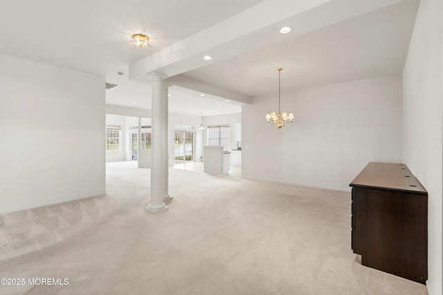 unfurnished living room featuring recessed lighting, an inviting chandelier, light carpet, and decorative columns