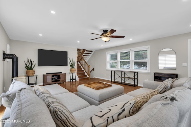 living area with baseboards, recessed lighting, wood finished floors, a ceiling fan, and stairs