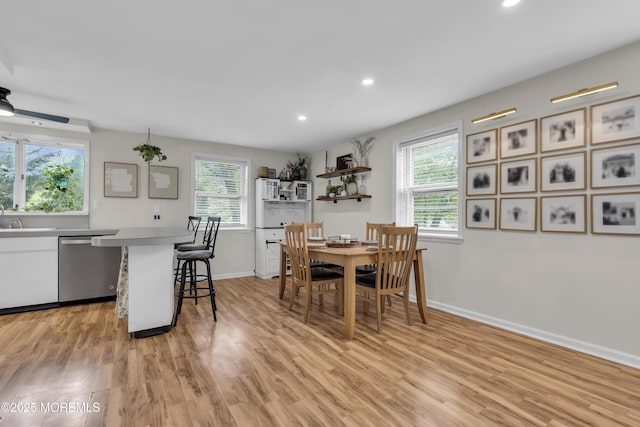 dining space with recessed lighting, light wood-style flooring, and baseboards