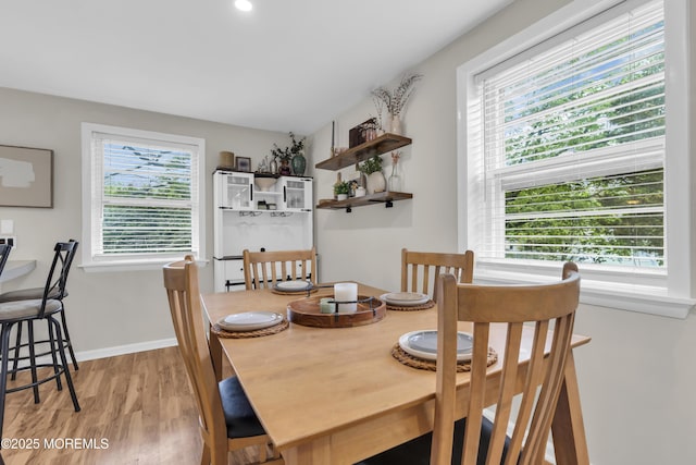 dining area featuring plenty of natural light, light wood finished floors, and baseboards