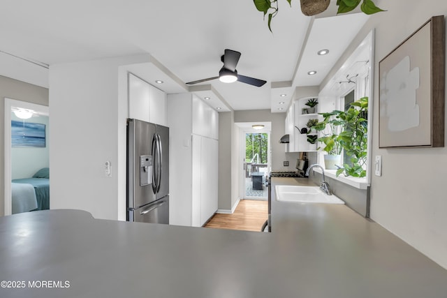 kitchen featuring a sink, stainless steel fridge, open shelves, a ceiling fan, and white cabinets