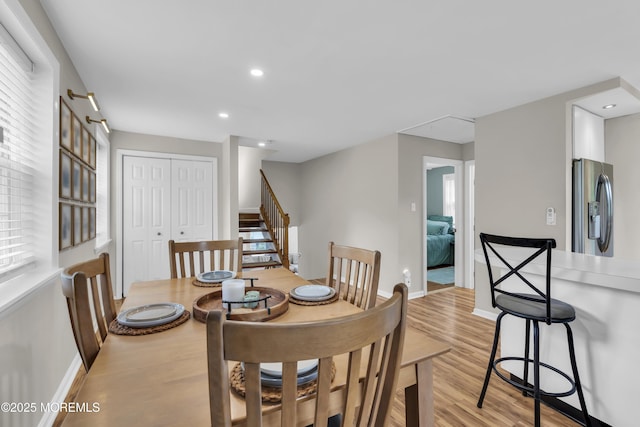 dining space with baseboards, recessed lighting, stairs, and light wood-style flooring