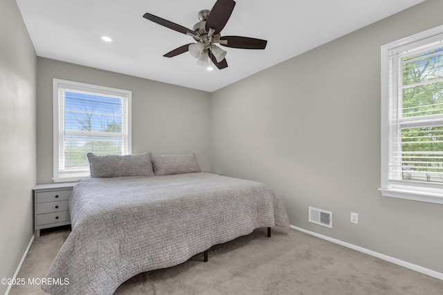 carpeted bedroom featuring baseboards, visible vents, multiple windows, and recessed lighting