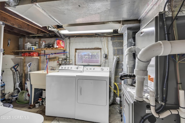 washroom with heating unit, laundry area, and washer and clothes dryer