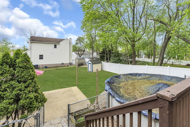 view of yard featuring a storage unit, a fenced backyard, and an outbuilding