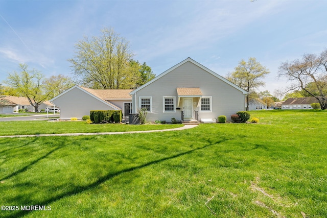 view of front of property featuring a front lawn and central AC