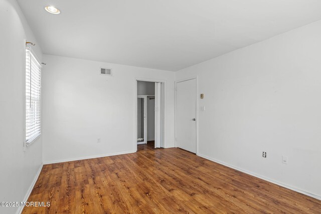 unfurnished bedroom featuring visible vents, baseboards, and multiple windows