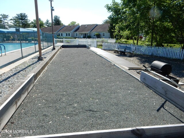 view of home's community featuring fence, a swimming pool, and a residential view
