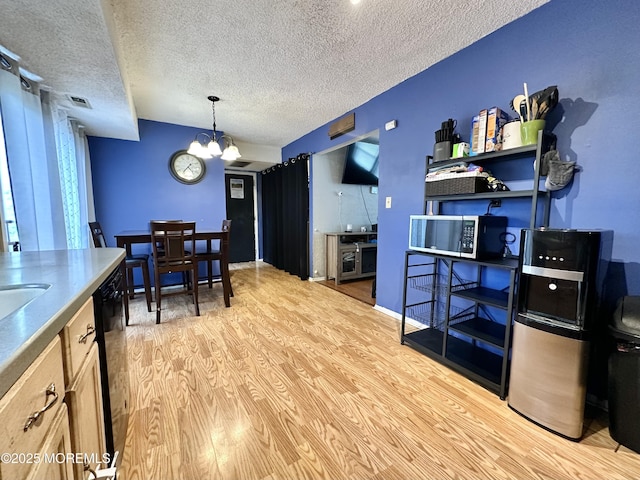 136 Windward Dr, Barnegat, NJ 08005 - kitchen featuring light wood-style flooring, a textured ceiling, stainless steel microwave, and a notable chandelier