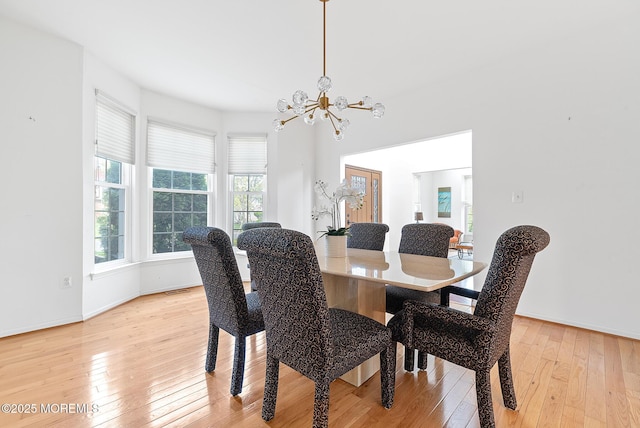 dining space with light wood-style floors, baseboards, a notable chandelier, and visible vents