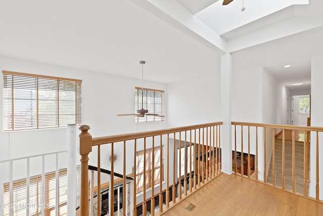 corridor featuring recessed lighting, hardwood / wood-style floors, and an upstairs landing